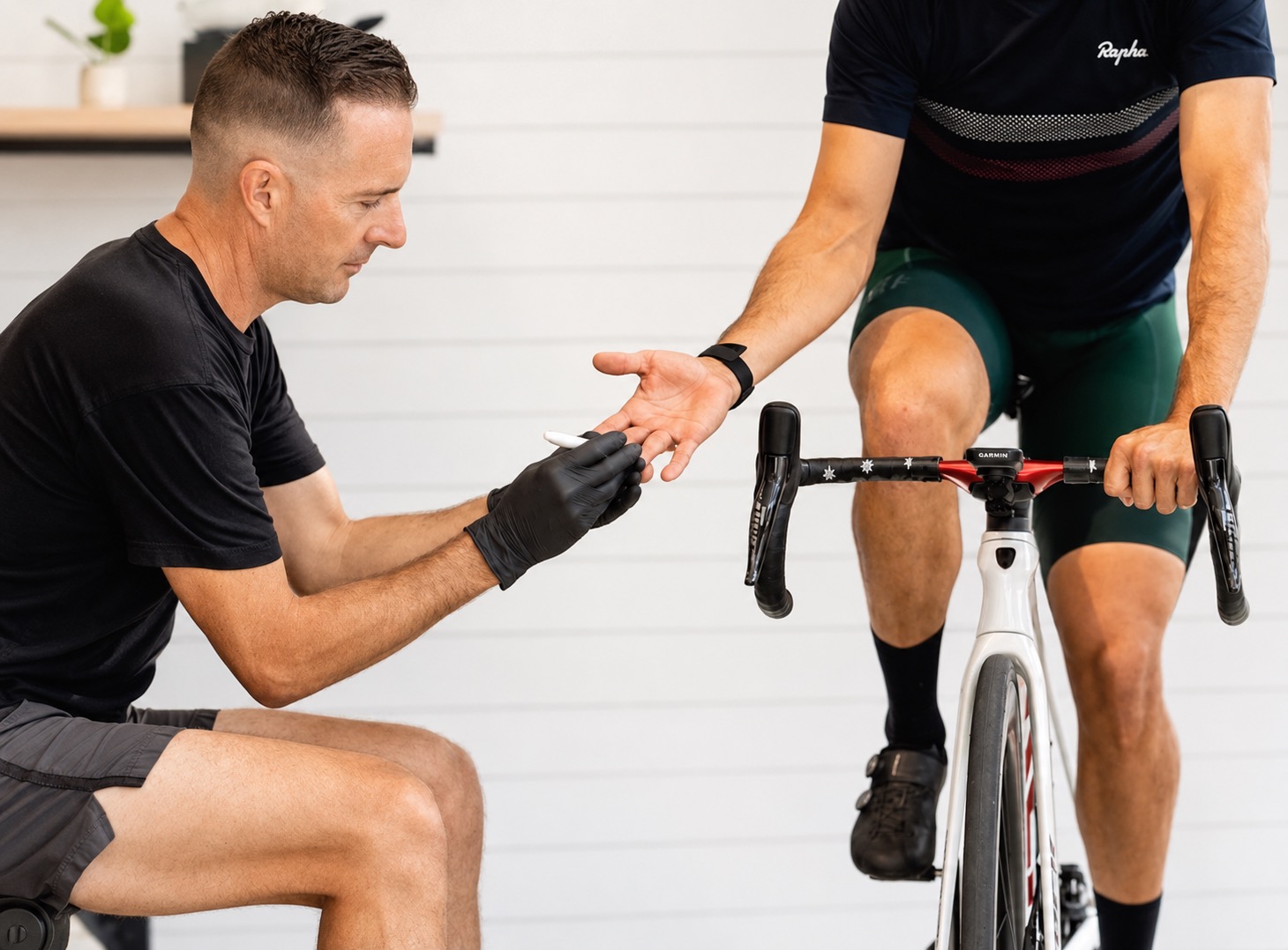 Gareth Thomas taking a fingertip blood sample from a cyclist during a lactate test at the lab in Santa Monica